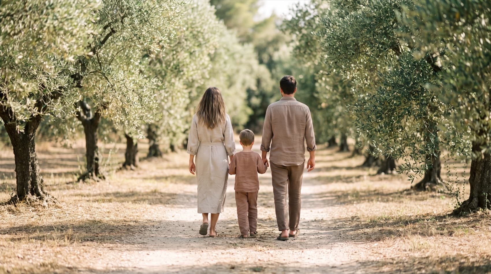 Zeytin ağaçlarının arasında birlikte yürüyen bir aile